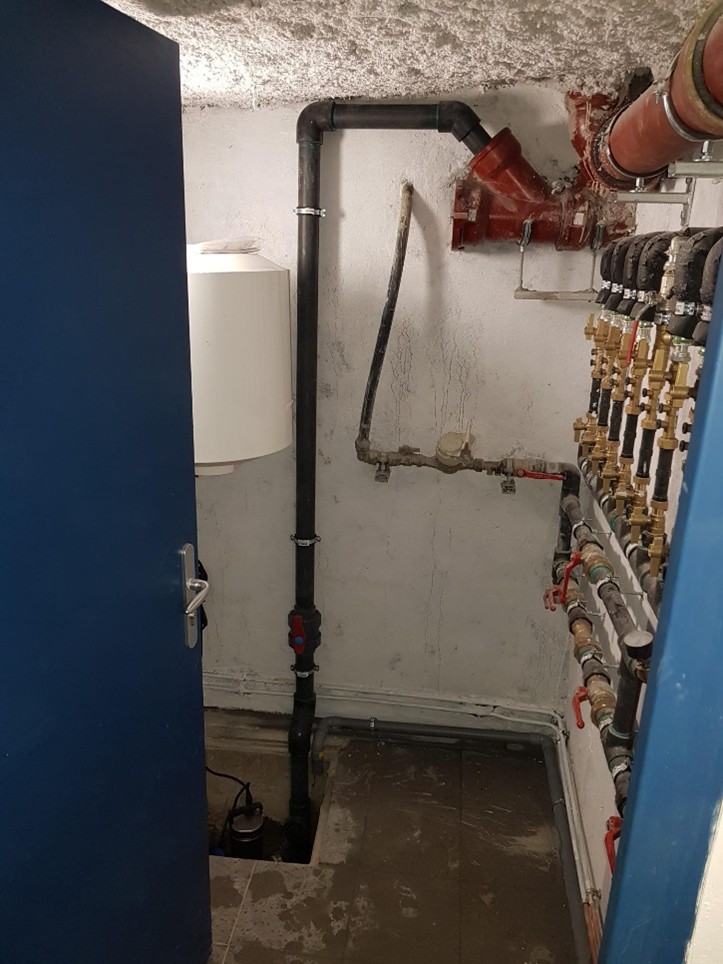 Pompe de relevage dans sa fosse avec colonne de refoulement et ballon tampon en partie haute